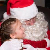 一个小女孩拥抱圣诞老人.